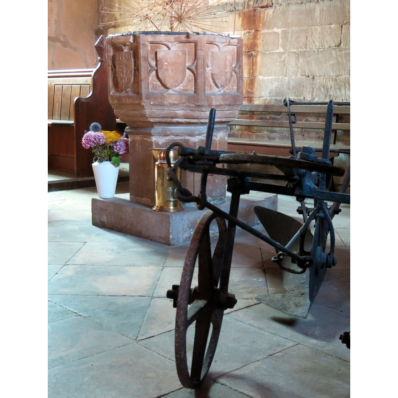 Source caption: "The 14th C. font with an iron plow, the Church of St Oswald, Howell, Lincolnshire, England".