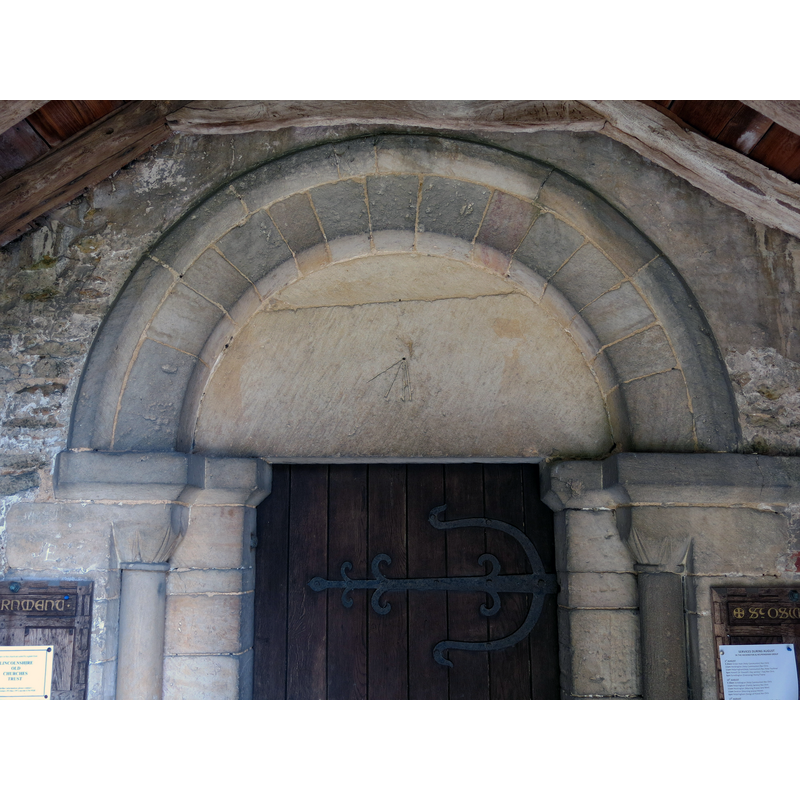 Source caption: "The Norman south porch doorway with plain tympanum and a mass dial, the Church of St Oswald, Howell, Lincolnshire, England".