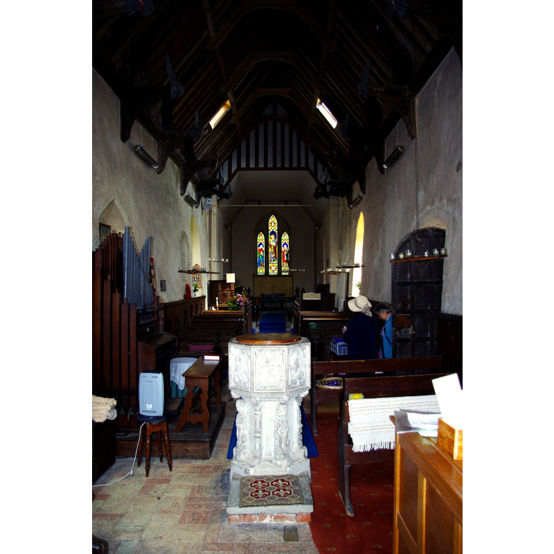 Source caption: "Inside St Edmund's Church. The north doorway and windows show that this church has Norman origins. The chancel, in red brick, was rebuilt and furnished by the Victorians, who also installed the two skylights in the simple medieval hammerbeam roof to let more light into the nave. The pulpit is Jacobean, and there are plain poppyhead benches."