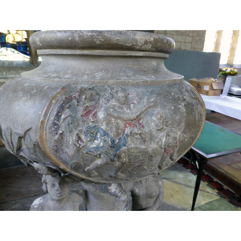 Source caption: "Church of All Saints: Paint on the Adam and Eve font. One of the carved panels on the bowl of the font still has some of the paint controversially applied in 1800 and subsequently removed at the behest of the congregation."