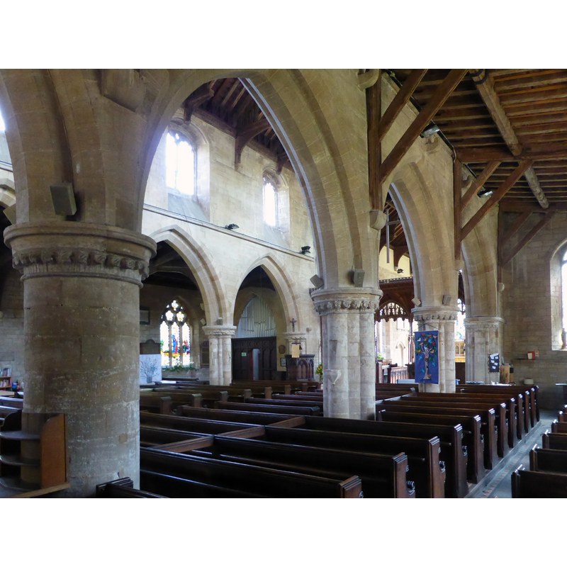 Source caption: "Church of All Saints: The Arcades. Looking from the South Aisle, through the South Arcade to the North one. The carved rood screen can just be made out in the middle".