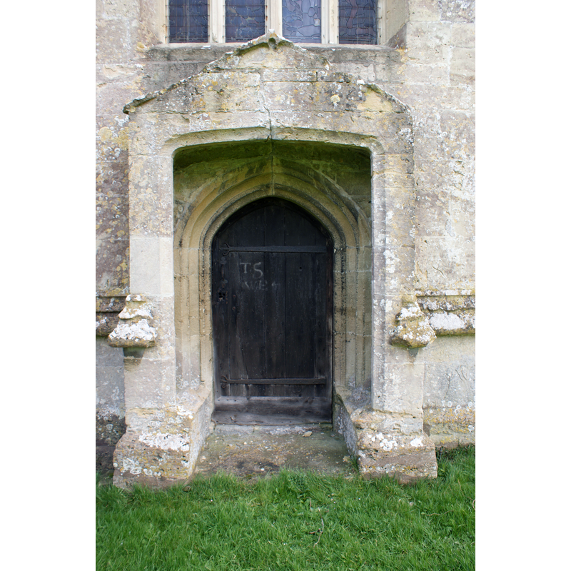 Source caption: "The West Doorway in the tower of 12th-15th Century Church of St. Mary's Burton, Nettleton, 03/14. The stone hood of the doorway effectively forms a small, shallow porch."