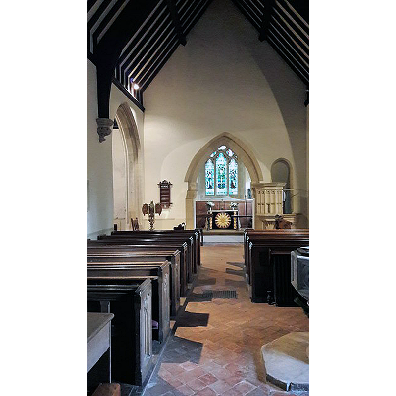 Source caption: "St James' church, Colesbourne. Largely rebuilt in 1851-2 to designs of David Brandon. The small size of the chancel arch is a clue to older origins." -- the font is partially visible in the foreground, right side