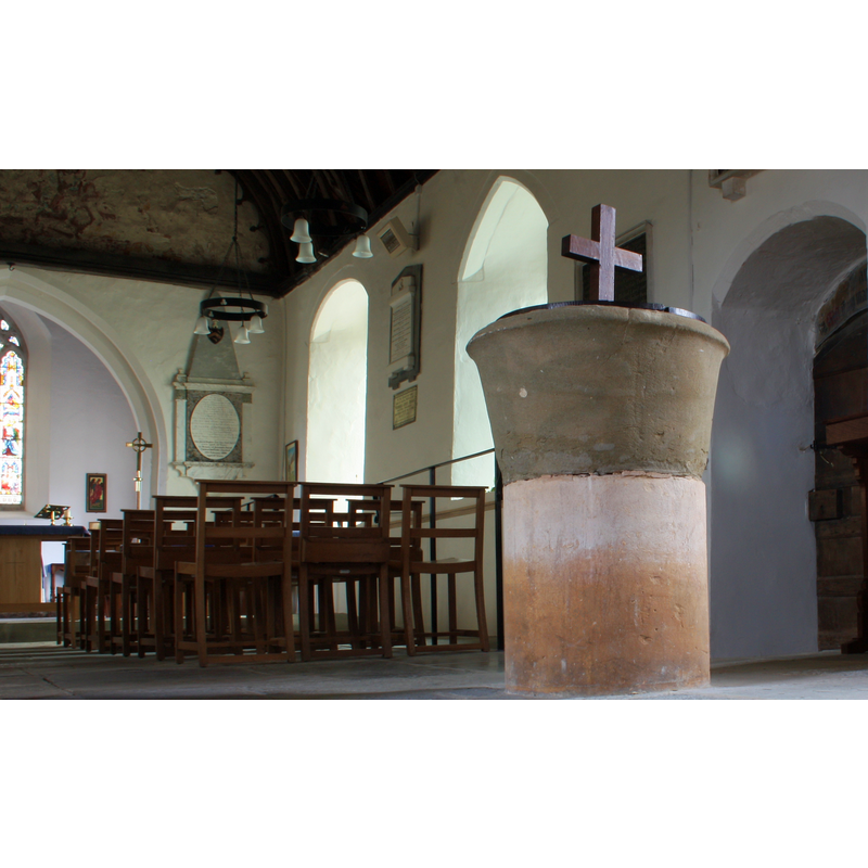 the font in the nave, by the south entranceway -- Source caption: "The font, Tirley church. Very old, Saxon or Norman, made from two Cotswold stones; the upper one being lead lined."