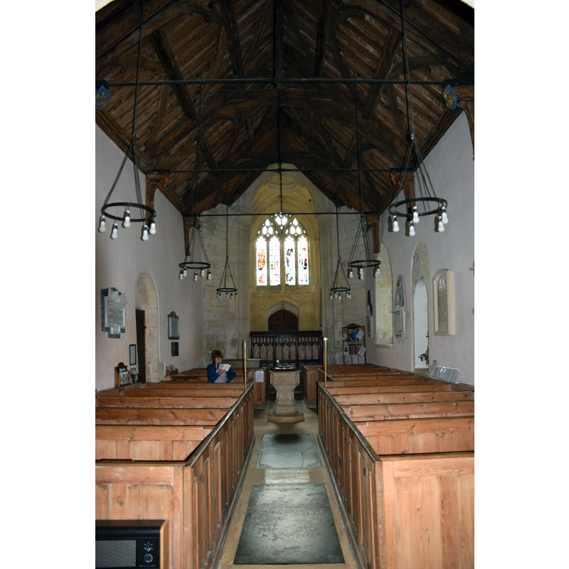 Source caption: "Pictured is the Norman (1160) nave looking towards the west tower and window. The box pews are 18th Century."