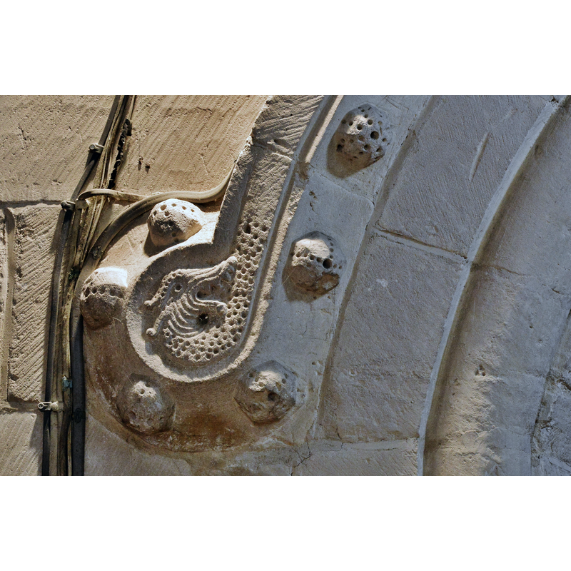 Source caption: "Bishops Cleeve, St. Michael and All Angels Church: Monster in a ball design on the Norman south doorway. This is on the interior side of the doorway."