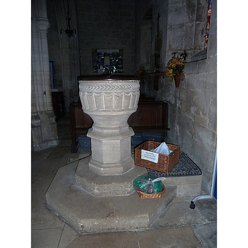 Source caption: "Font, St James the Great, Bratton. Looking very fresh and new it is in fact a Norman bowl, set on a 15th century base. It was recut in 1860, so it appears much newer. There are traces of a medieval iron hinge and lock, used to protect the baptismal water."