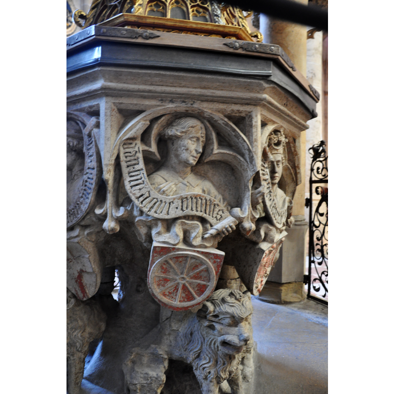 Source caption; "Ulm, Ulmer Münster, Taufstein (1474), Detail: Figur mit dem Wappen des Kurfürsten von Mainz".