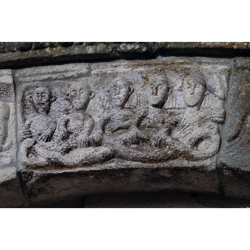 five seated men in the west portal of the Romanesque church in May 2010, a composition somewhat similar to the one carved on one of the sides of the baptismal font at Airainnes, Somme, France