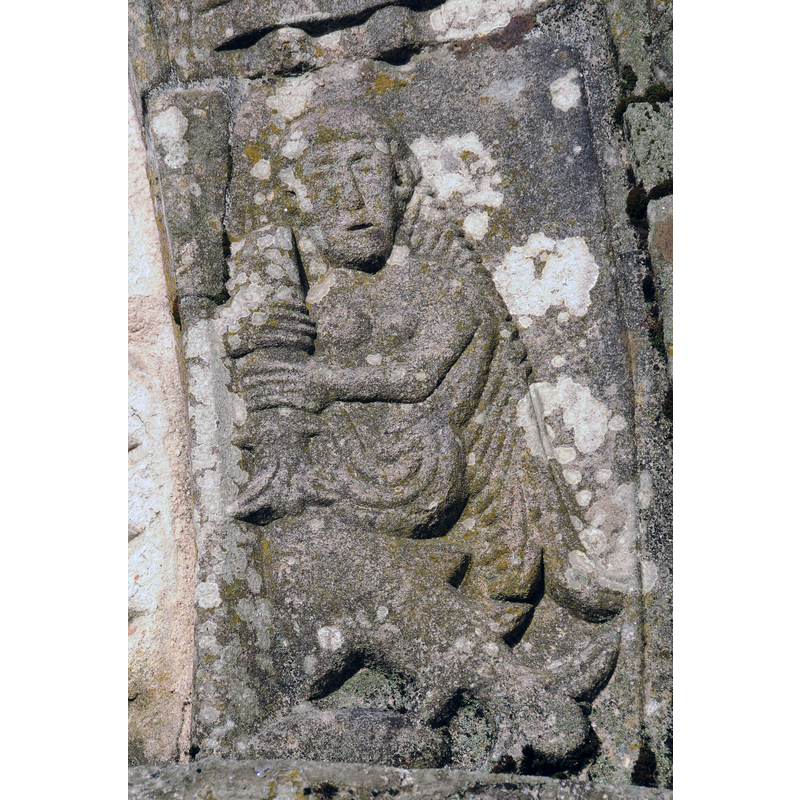 a mermaid (?) in the west portal of the Romanesque church in May 2010 [the human  upper body has female breasts)