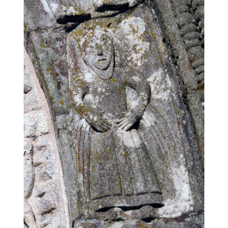 a standing woman in the west portal of the Romanesque church in May 2010
