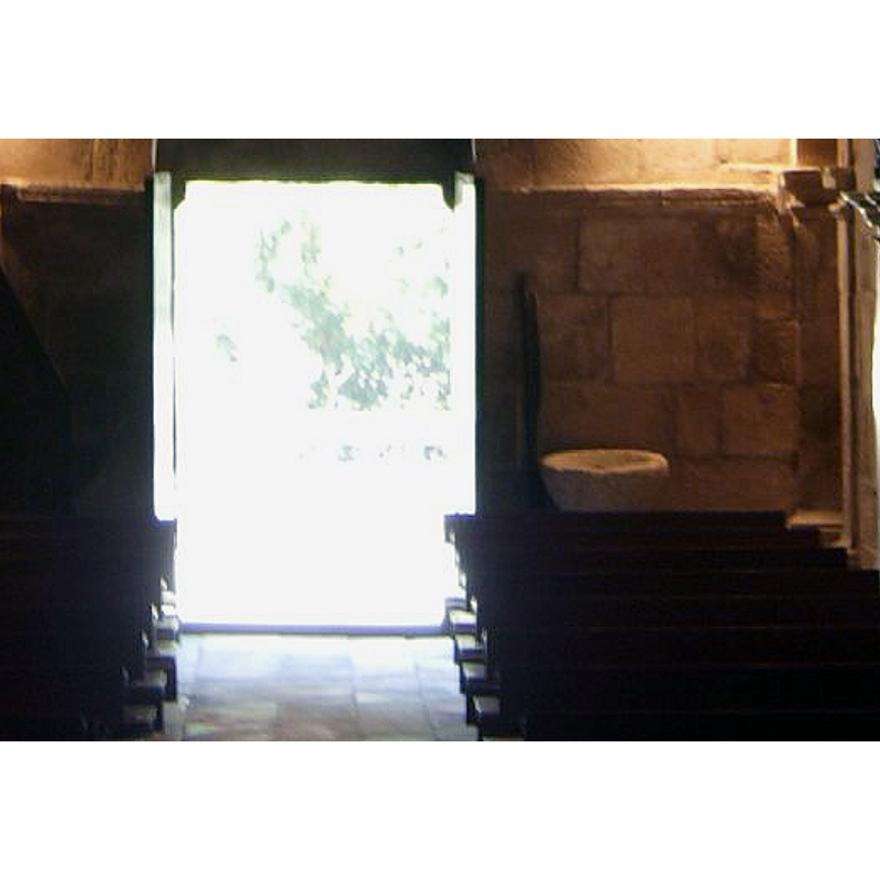 a stone vessel visible at the far end, to the right of the doorway; it is probably used as a holy-water stoup; the present font in use is located at the east end of the nave, by the north pillar of ther chancel arch