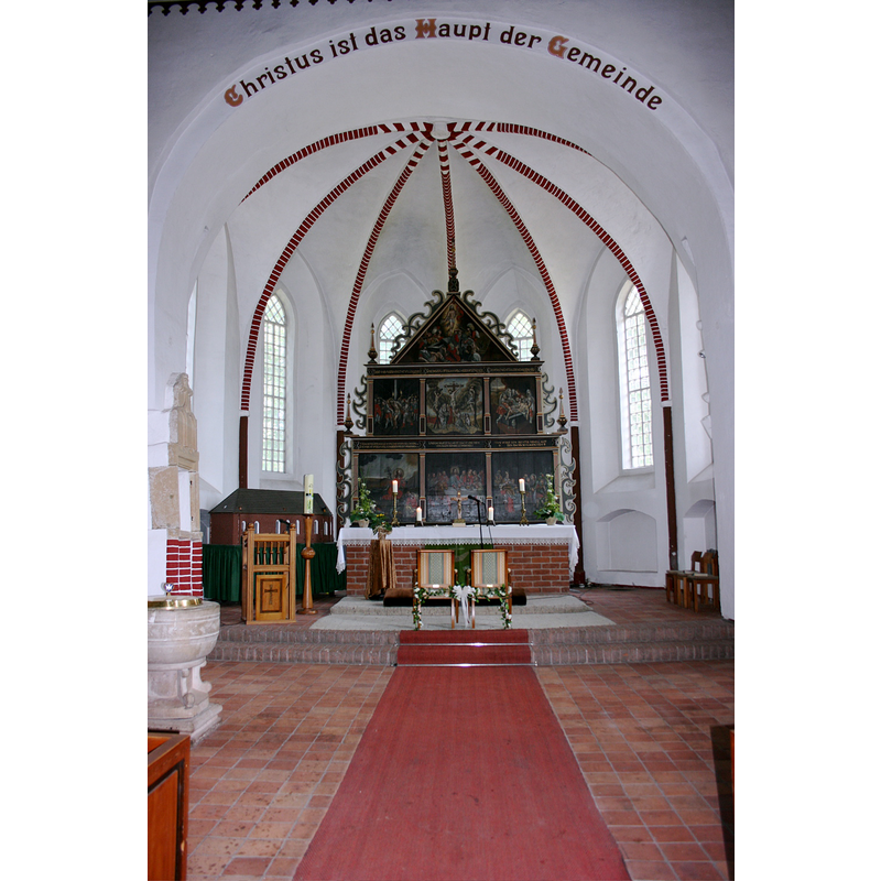 the baptismal font is partially visible on the left [north] side, just west of the inscribed chancel arch