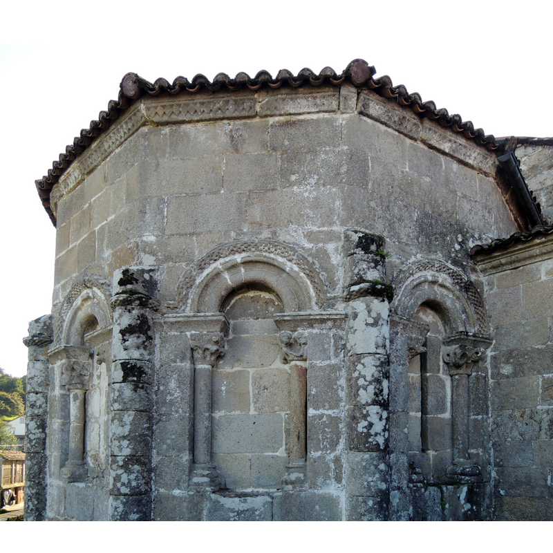 Source caption: "El ábside pentagonal está precedido por un tramo recto. En cada uno de los cinco paños se abre una ventana con arcos de medio punto apoyados sobre capiteles con diversos motivos. Por desgracia, tan solo conserva las tres más septentrionales."