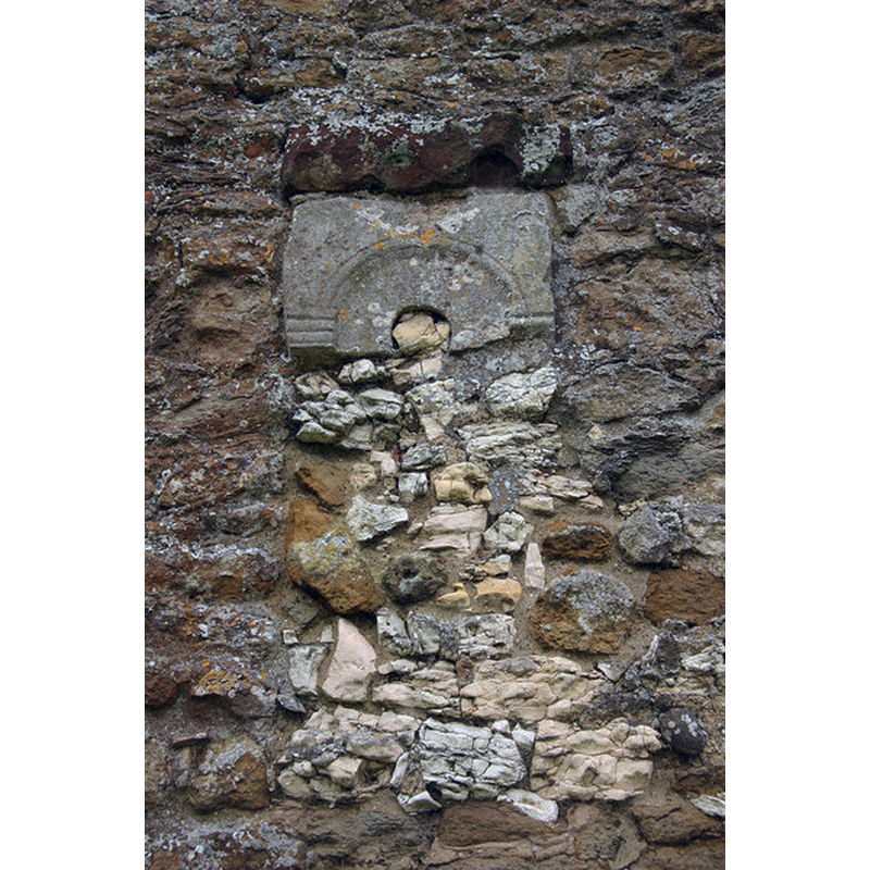 Source capion: "Saxon window. Fragmentary remains of an 11th century window in the north chancel wall of St.Mary's church" [NB: the entry for this church in the CRSBI [www.crsbi.ac.uk/site/5311/] [accessed 6 May 2019] notes: "A small window fragment in the chancel may be late 11thc [...] The window fragment in the chancel is similar to the tower window at the church of St John the Baptist, Great Hale, in terms of its small scale and monolithic manufacturing process. Everson and Stocker (1999), 311, date the Great Hale window to the late 11thc, the period of transitional overlap between the Anglo-Saxon and Romanesque periods. The stone block above the North Cockerington window fragment is badly weathered, but, based on its undulating surface, it too may have carried carved ornamentation in the form of a row of semi-circular cusps."]