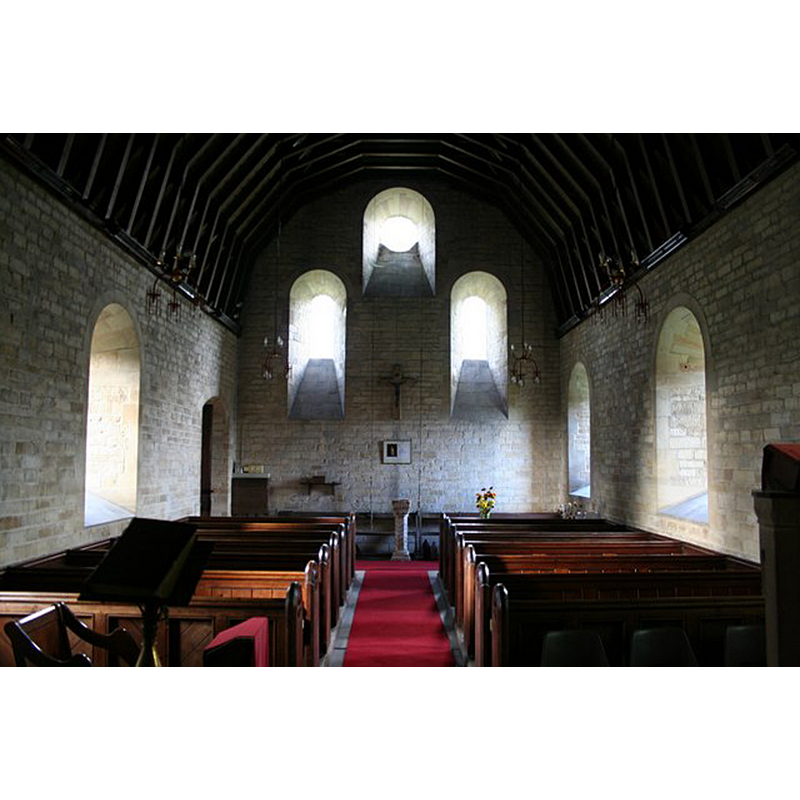 Source caption: "St.Lucia's church nave, Dembleby. Looking west with neo-Norman deeply splayed windows"  Recycled late-Norman piscina or stoup from the earlier church is visible at the far end, now used as font