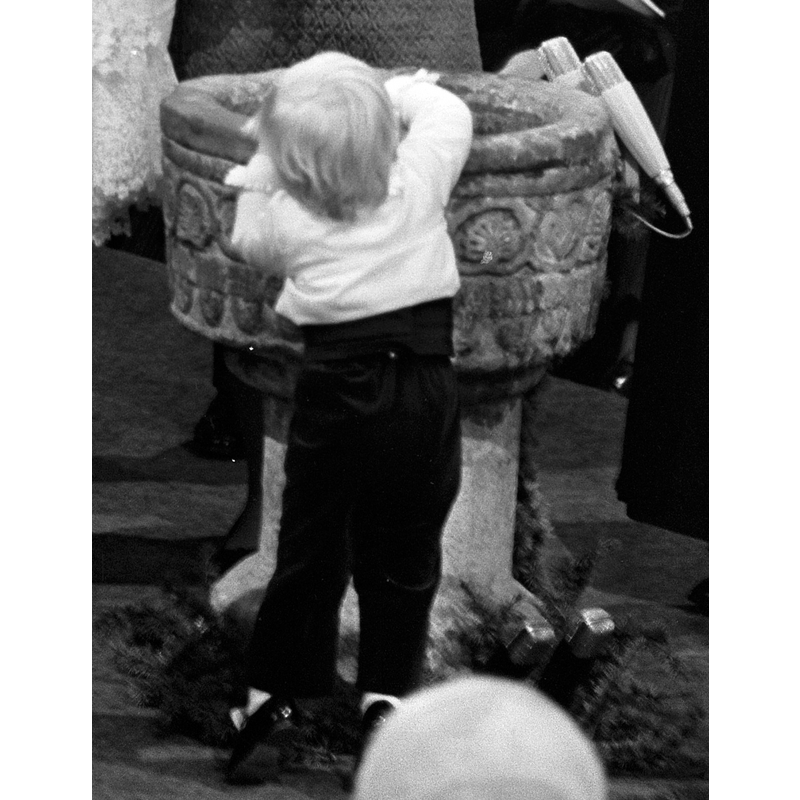 detail of a photograph taken during the baptism of prince Johan Friso; the child reaching into the old font is prince Willem Alexander