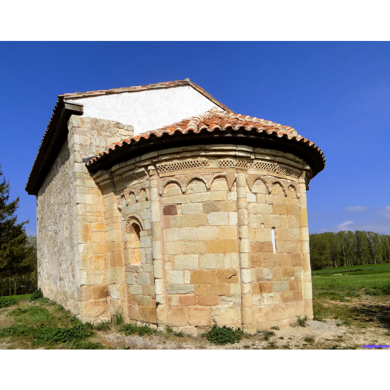 Source caption: "La ermita de San Pelayo, un poco separada del casco urbano, es uno de los monumentos más antiguos del Románico palentino. Es un pequeño edificio de planta muy sencilla. El ábside presenta decoración de arcos lombardos, muy extraña en Palencia; la portada reutiliza fustes y capiteles de un edificio anterior, mozárabe o visigodo. En el interior se conservan los restos de las pinturas románicas más destacables de la provincia. Se aprecian todavía bien los apóstoles y figuras de los meses del año, mientras que el Pantocrátor con el Tetramorfos del cascarón se ha perdido casi por completo. El conjunto de la ermita corresponde a los años finales del siglo XI."