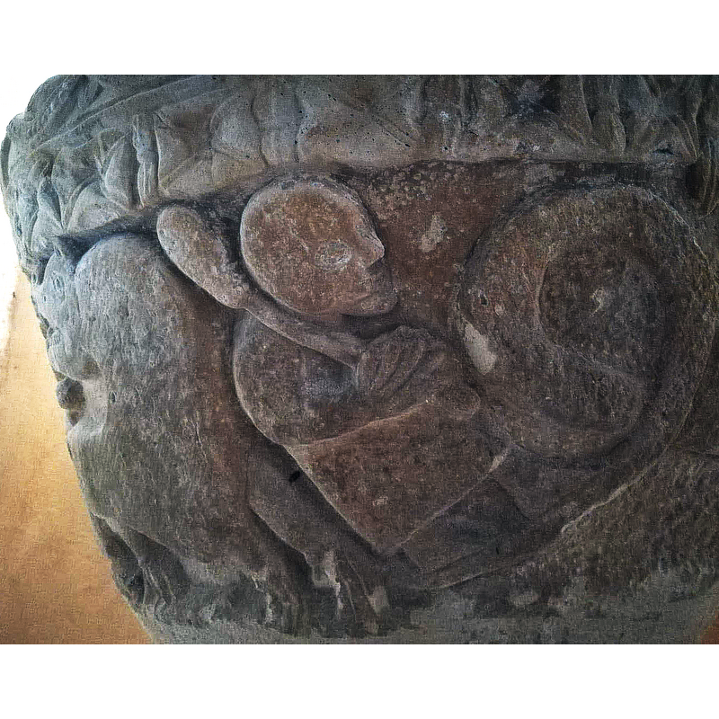 a male figure, is seen here looking towards the righht and carrying a large club, attacks a monster from behind, while another figure, not visible here, stabs the monster from the front; only the the curled part of the beast's tail is visible here on the right [approximately on the north to northwest side of the basin]