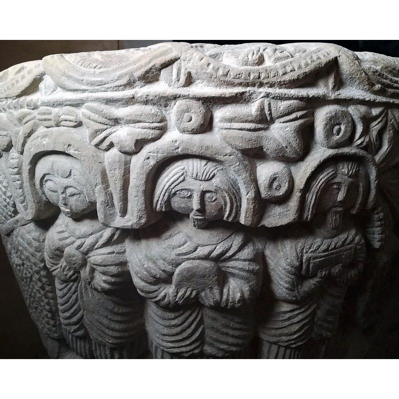 three figures stand full front dressed in hieratic garb; two are clearly bearded; all three are holding objects: one may be a Host, another a book or a box...