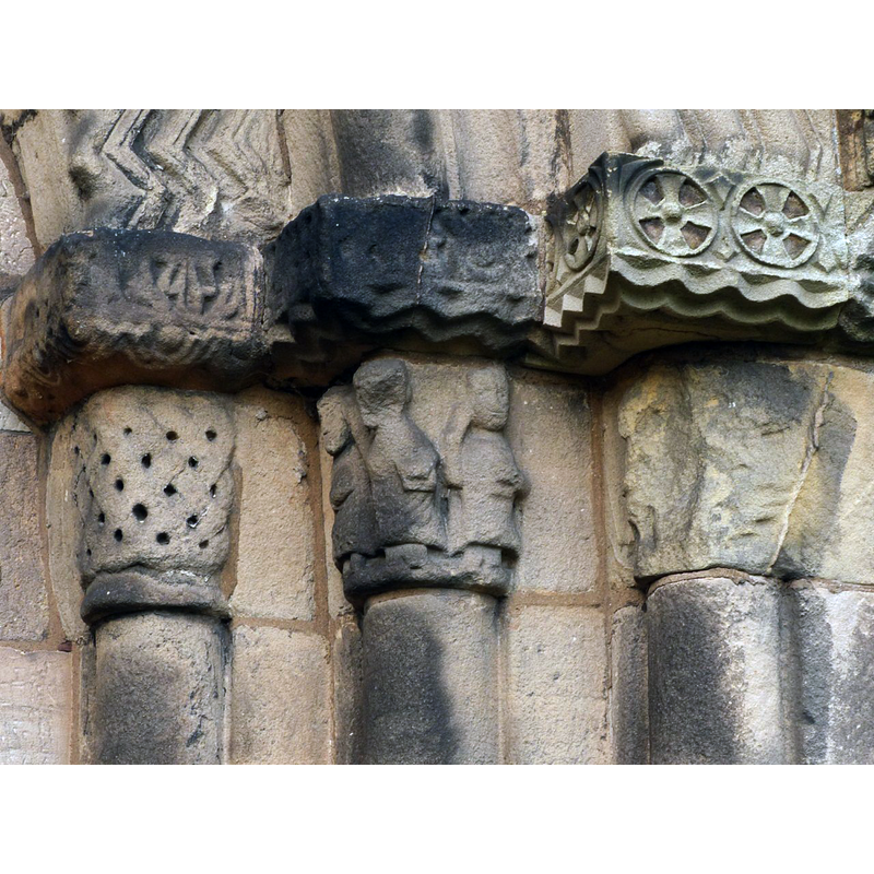 Source caption: "Capitals of the south door. The central capital is the church's only example of human figures from the Norman period. The basket weave to the left is also unlike anything else."