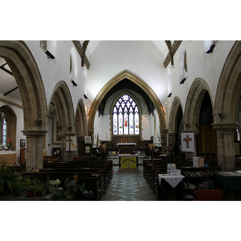 Source caption: "The nave was last restored in 1855 at the cost of £677. It has four bay arcades supported by quatrefoil piers. All are leaning very much out of the perpendicular. The roof beams are supported on ancient corbels with face carvings."