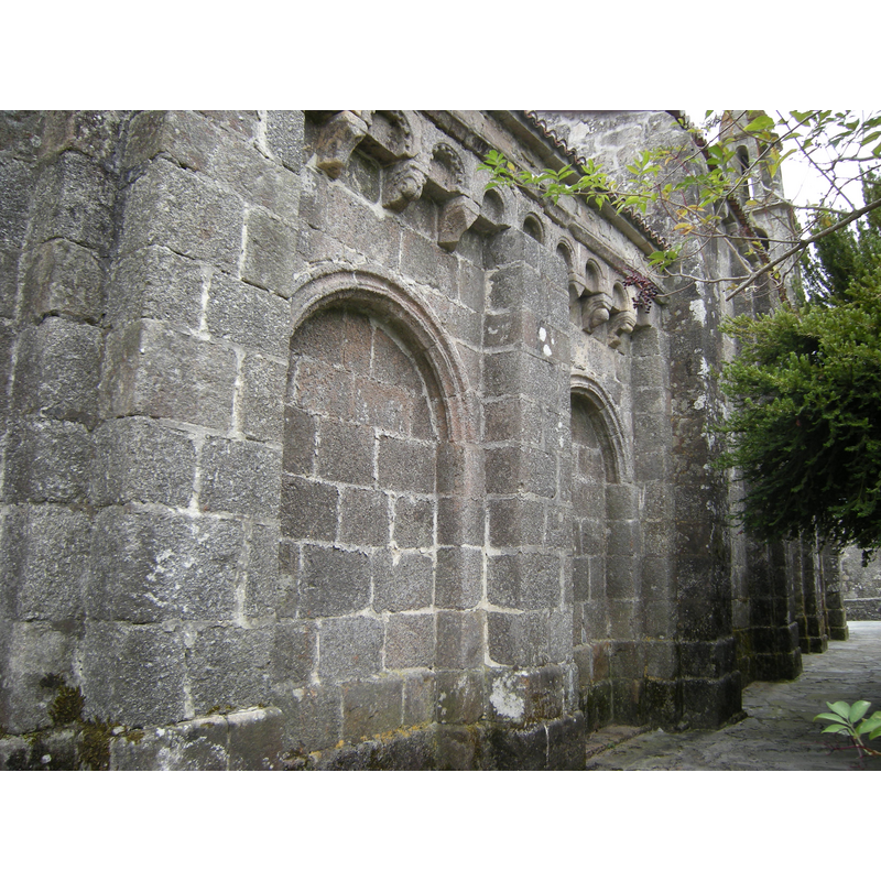 Source caption: "El muro norte del ábside se divide en dos paños con sendos arcos ciegos. La cornisa está decorada con arquillos apoyados sobre canecillos."
