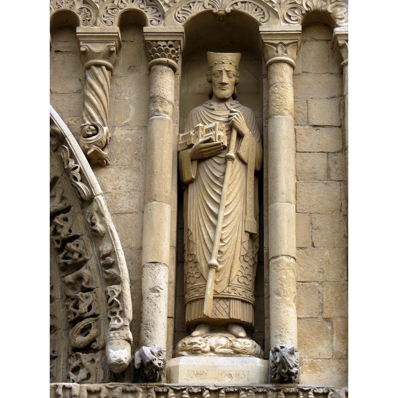 Source caption: "Statue de John I, évêque de Rochester (1125-1137), sur la façade occidentale de la cathédrale de Rochester."