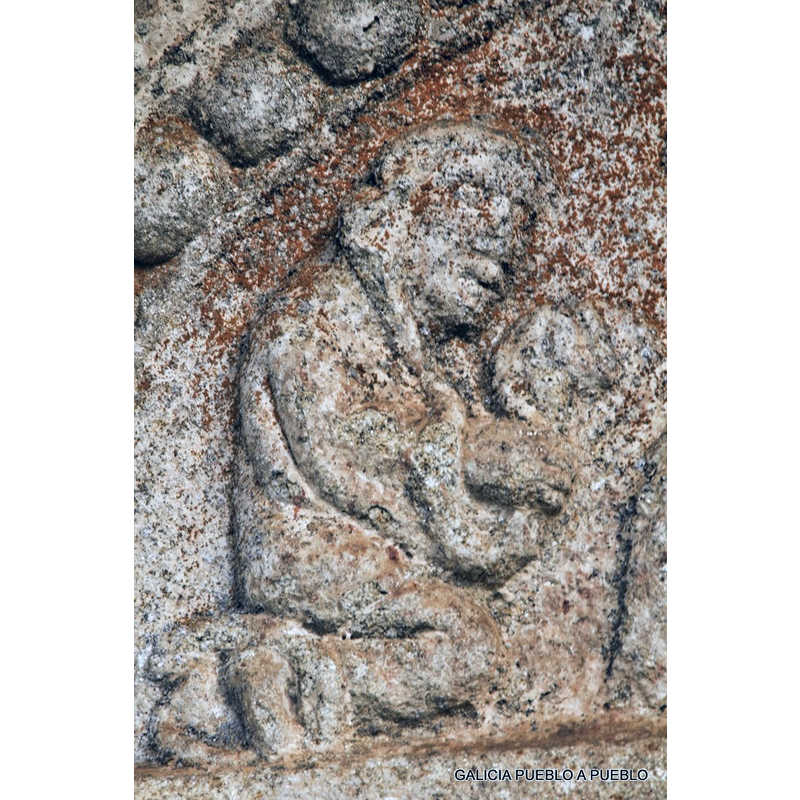 Source caption: "El personaje humano viste una larga túnica, pudiera lucir corta barba y no es larga su cabellera. Presenta un recogido y devoto semblante, pero sin mirar a la Mano que lo señala. Con las manos puestas delante del pecho, agarra, por debajo de su voluminosa cabeza en alto, una larga culebra. Cuelga el oficio, primero por debajo de su brazo derecho, alargándose luego hasta el pescuezo del Señor, volviendo a quedarle colgada su última parte por el otro lado del cuello. Hay quien identifica la figura de la serpiente con un niño puesto en los brazos de esa figura humana."
