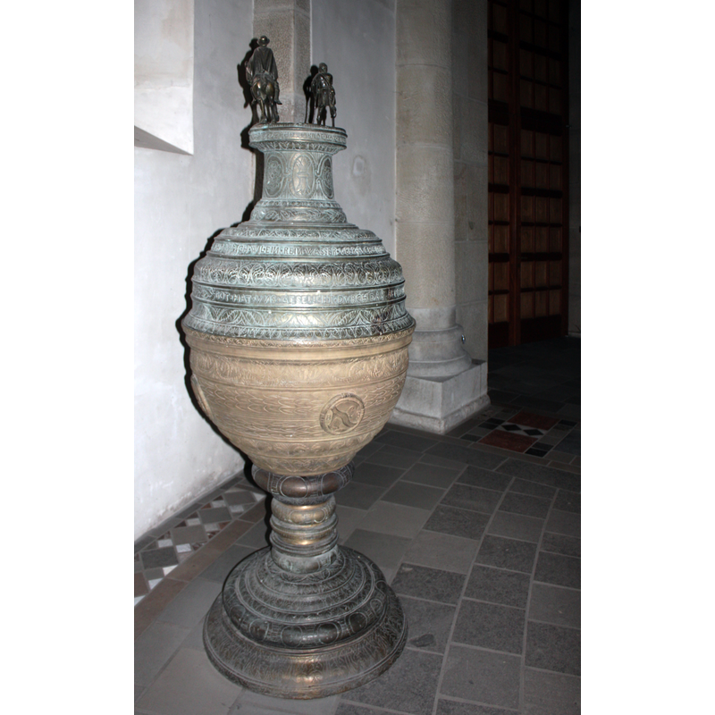 Source caption: "Klein St. Martin, Taufbrunnen mit einem Becken aus Bronze um 1594. Die Deckelbekrönung stellt den hl. Martin dar, gegossen von Heinrich Wickerath. Heute in der Kirche Maria im Kapitol, Köln." -- NB: the font itself does not match Walker's desciption [cf. FontNotes] but the cover does