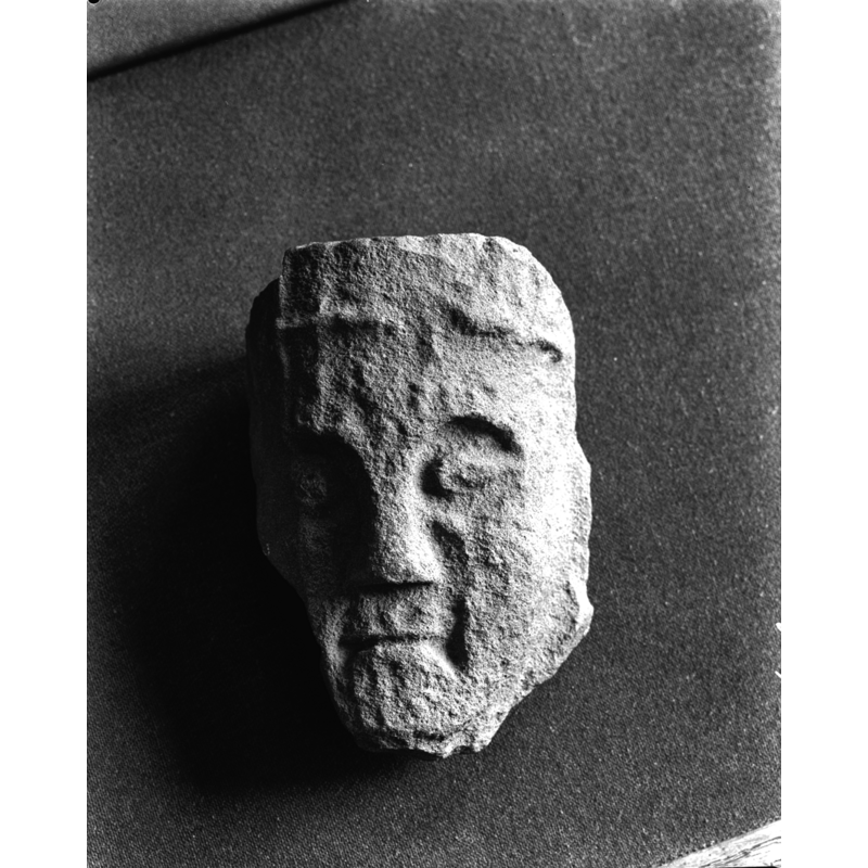 the source caption reads: "Hervormde Kerk En Toren: kerk, Consollekopje", but it has been identified in one source [cf. FontNotes] as one of the four heads of the former medieval font of the church here