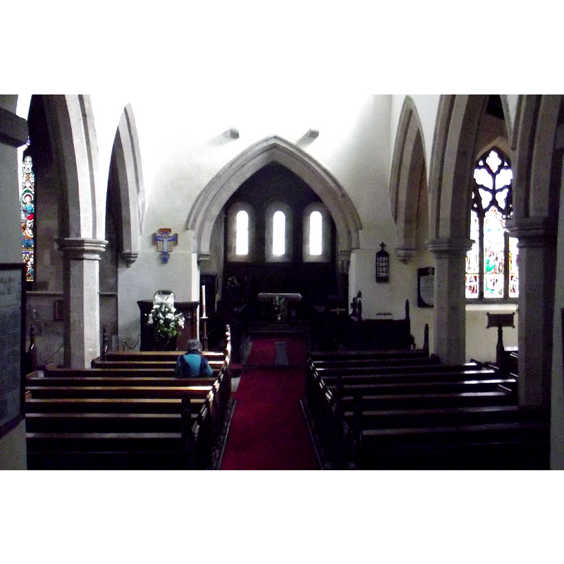 Source caption: "Looking east in St Agatha's Church. The Norman nave is flanked by 14th-century [a]isles with their Decorated arcades and windows. The three Norman-style windows at the east end of the chancel date from the Victorian restoration in 1845. The two corbels above the chancel arch would originally have supported a rood loft."