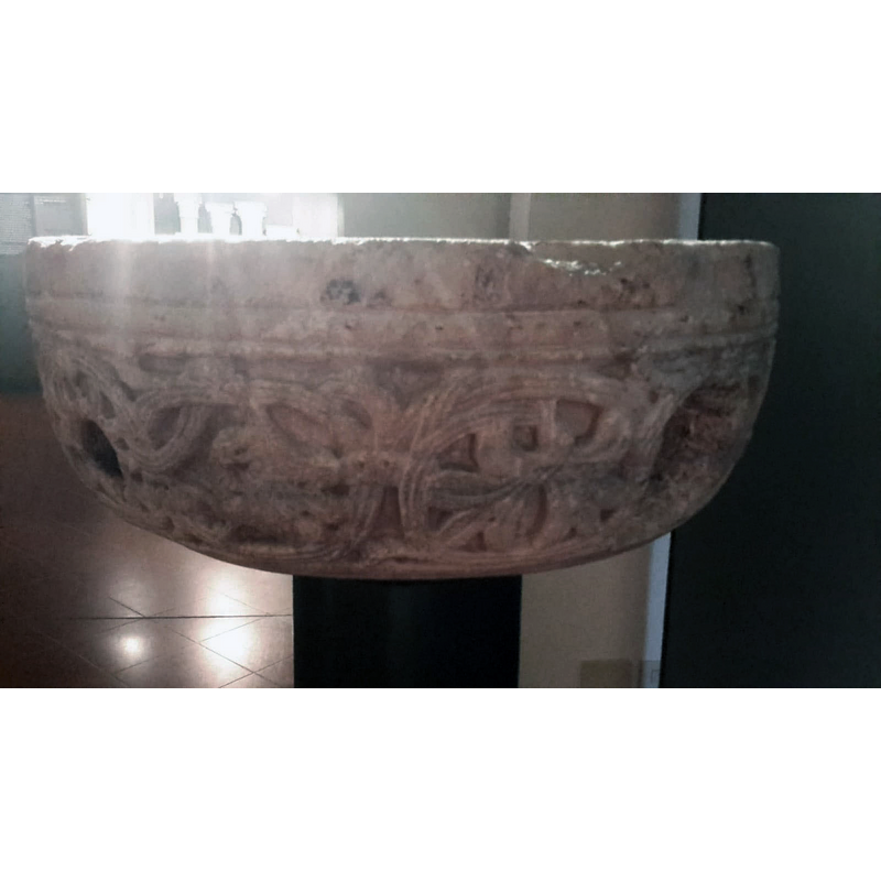 showing two of the large holes in the underbowl; the museum label suggests the basin may have been used as a fountain at some point, hence the large drains on the sides