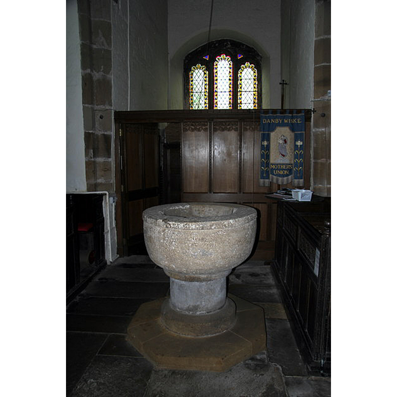 Source caption: "Norman Font, Danby Wiske Parish Church. "This simple but massive stone font is one of a very few in this area to survive from early times. Such symbols of the Roman Church were a popular target for destruction by extremists during both the Reformation and Cromwell's Protectorate. This font must have been carefully hidden away until the threat from iconoclasts had abated"." [NB: the quoted text in the caption may be from a local source].