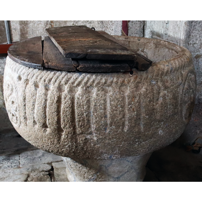 the row of figures to the left of the scene(?) appear now as flat ribs due to erosion; at the extreme left is another hexafoil motif inscribed in a circle