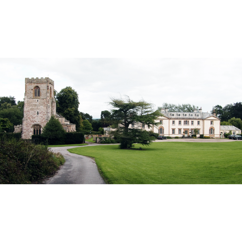 Source caption: "Kirkby Fleetham church and hall. The view encompasses the two most important buildings in Kirkby Fleetham, yet both are over half a mile from the village. As can be seen here, St Mary's church is very much an estate building and is adjacent to Kirkby Hall, a late 18th century country house. The most obvious feature of the church is the solid looking Perpendicular tower, though there are other fragments within the building that date back to the 12thC."