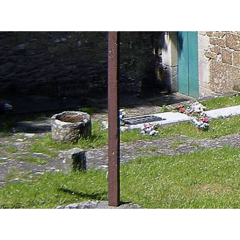 one of two cylindrical objects resembling a baptismal font llocated just outside the church here; this one is located near the west doorway; is it a font?