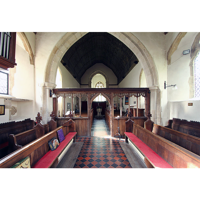 view west through the chancel screen; the baptismal font is visible at the far end in the centre aisle