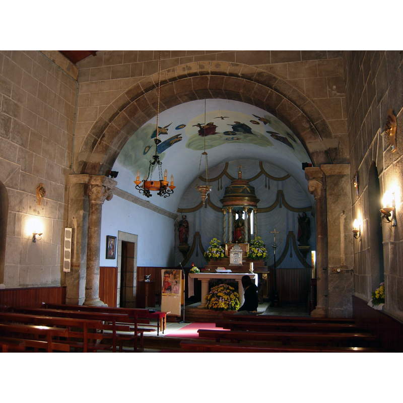 Source caption: "El interior de la iglesia conserva de su primitiva fabrica el arco triunfal de medio punto apoyado sobre capiteles con motivos vegetales, y los muros laterales de la nave."