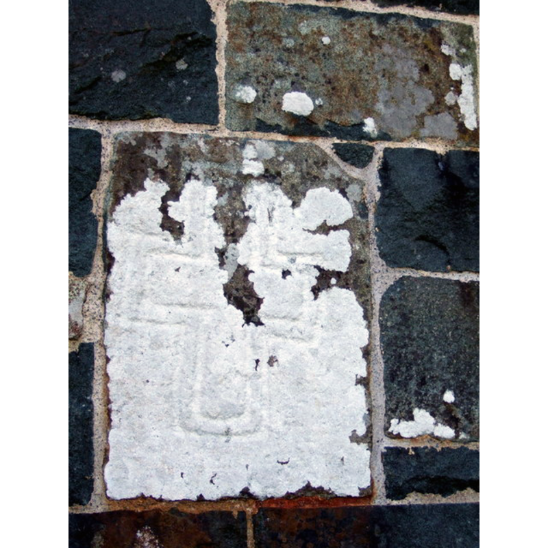 Source caption: "Pillar stone, St Gwyndaf's. One of the incised stones set in the church wall. There is a theory that these crosses were a means of laying claim to pre-existing 'pagan' sites."