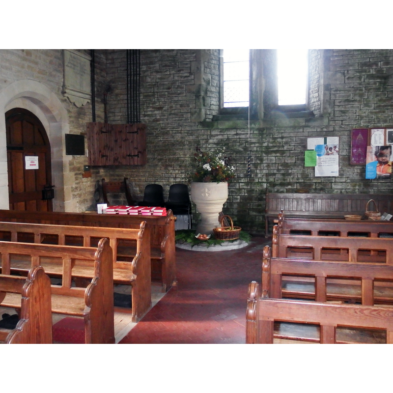 the modern font and cover at the west end of the nave