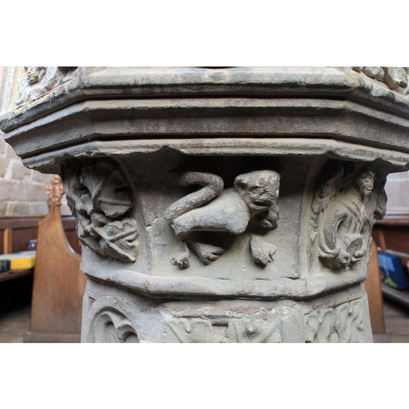 in the centre panel; much damaged; appears feline, with the raised tail over the rump, usually present in the carvings of medieval lions