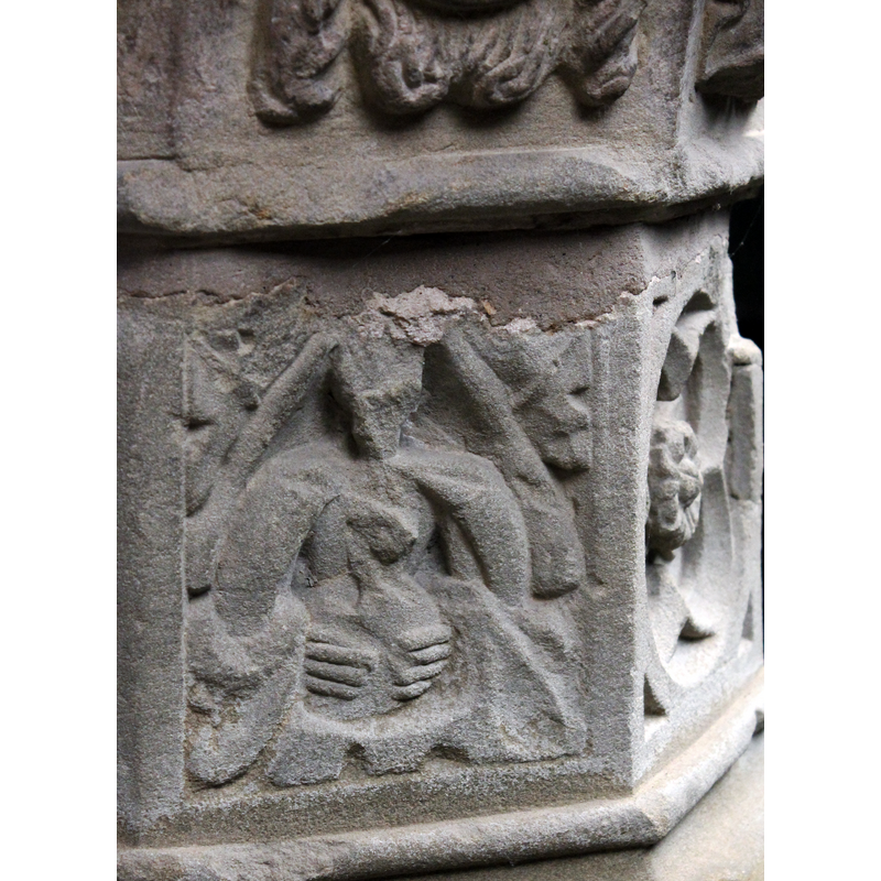the panel is much damaged now; there appears to be a human demi-figure framed atop by a pounted arch, with foliage in the spandrels; the figure appears to be holding an object, the fingers of both hands clearly visible