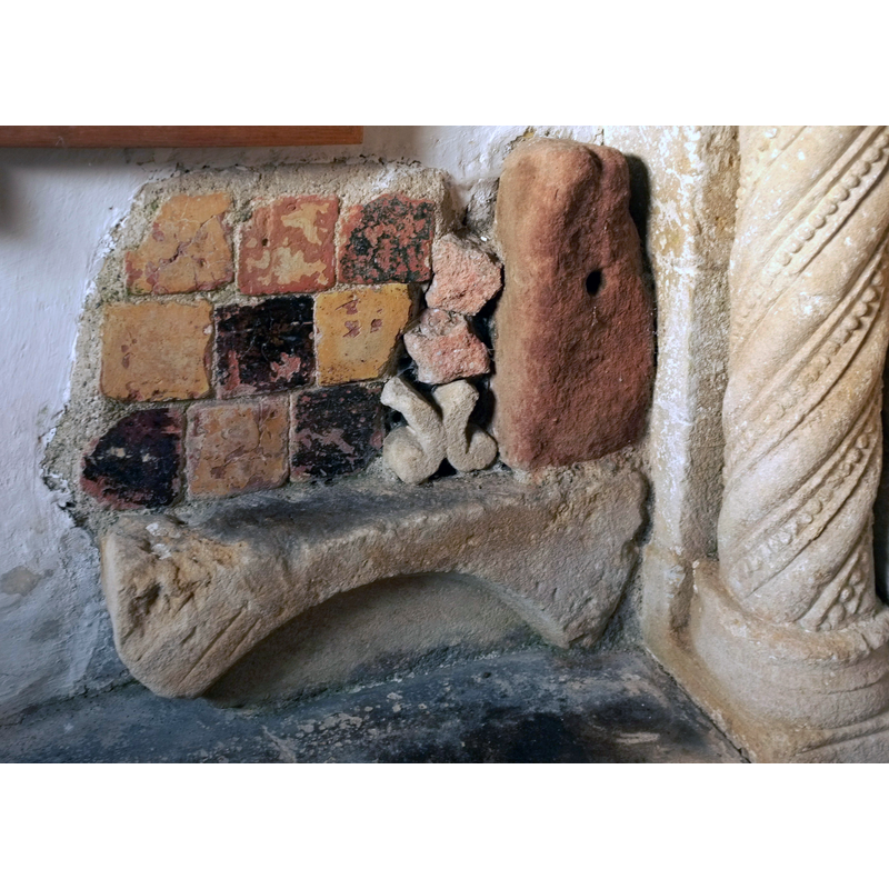 Source caption: "Tiles, St Mary Magdalene's church, Langridge. With some stone fragments in a corner of the porch, beside one of the "beaded and spiral moulded columns with scalloped capitals" of the C12 south door"