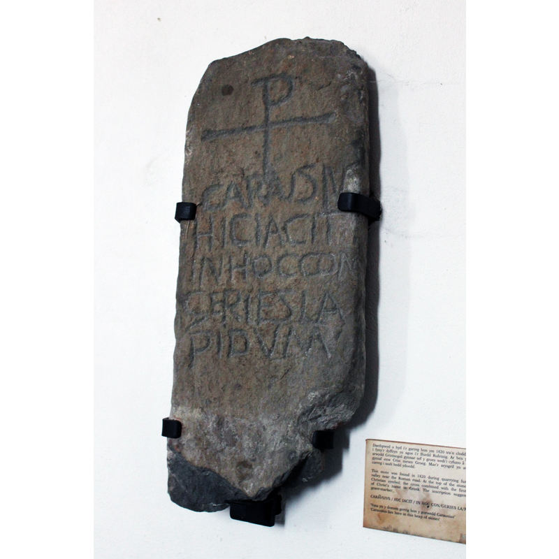 one of several inscribed or decorated stones of Early Christian origin; this one is inscribed with the CHI RHO monograpm for Christ and the text: "CARAUSIUS / HIC IACIT /  IN HOC CON/GERIES LA/PIDUM" [cf. FontNotes]