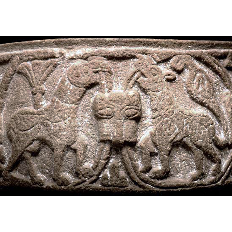 on the basin sides: two facing quadrupeds inscribed in circles linked by lion heads; the one on the right appears to be a lion; the one on the left a fabulous beast with a beaked head; notice how the carver is not constrained by the demarkating circles and over-rides the boundaries at will -- on the underbowl: part of the Nativity scene, the Child in the manger
