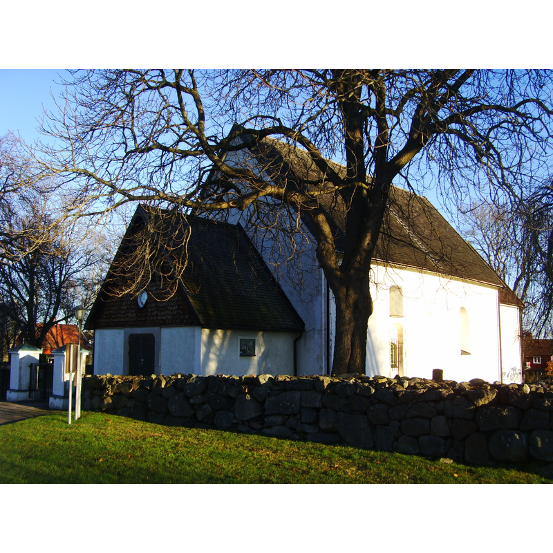 the west porch or 'vapenhus' is a later addition to the medieval church -- the window-like opening on the south sides, immediately to the right of the trree, was the original south entranceway