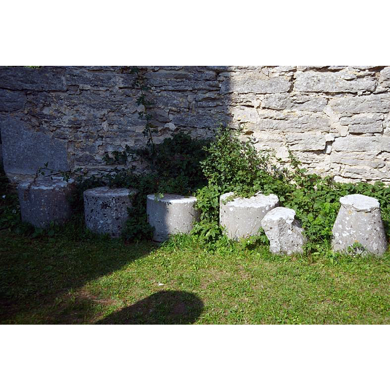the base of the font seen here on the extreme right -- Source caption: "Hela kyrkobyggnaden synes ha uppförts vid 1200-talets mitt. Ruinen består av ett kvadratiskt kor och ett rektangulärt långhus. Redan vid 1500-talets mitt tycks den ha varit mycket förfallen och övergavs förmodligen under 1600-talet."