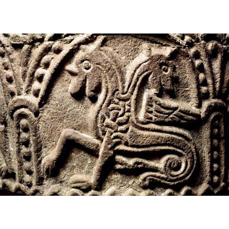 passant to the left, with the second head regardant; the tail end is a head, as expected in an amphisbaena; notice interlace pattern at chest level