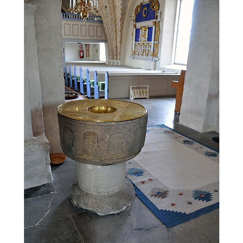 the medieval font, seen here inside the chancel, by the south chancel arch pillar -- the font has obviously been moved; originally it would have been by the main entranceway of the church; a photograph taken in 2003 showed the font in the northeast corner of the nave